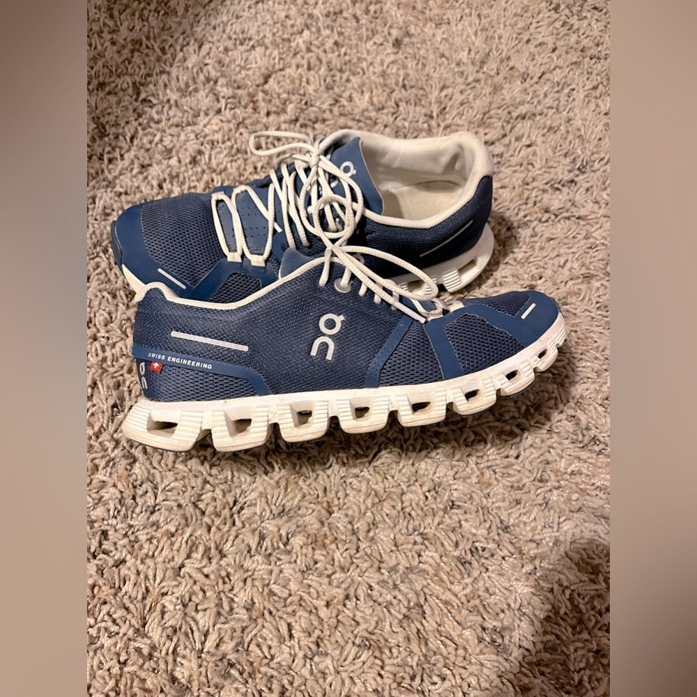 Women’s size 6.5 navy blue and white ON running clouds.